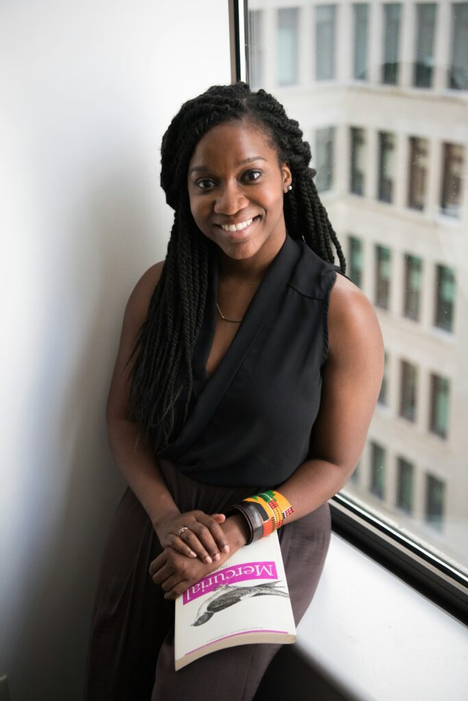 Femme professionnelle noire tenant un document imprime en ville